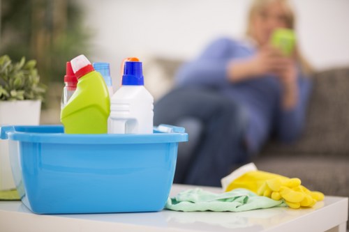 Professional cleaner maintaining meeting room surfaces in a W8 office